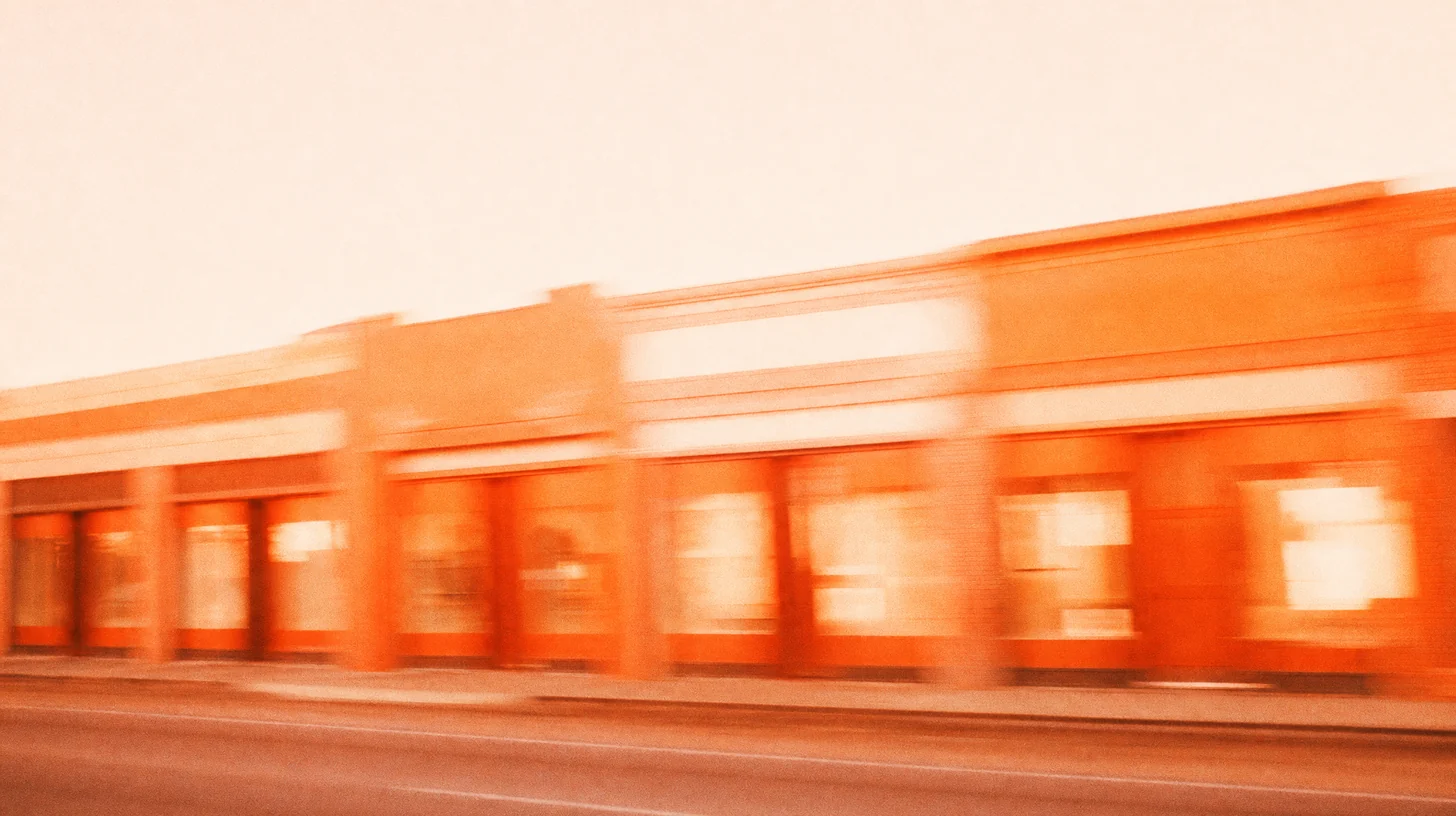 Photographie filée : une rangée de devantures de magasins identiques, étirée par le mouvement