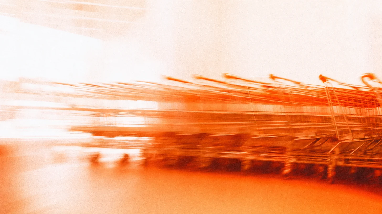 Photographie filée : une file de chariots de supermarché emboîtés, étirée par le mouvement