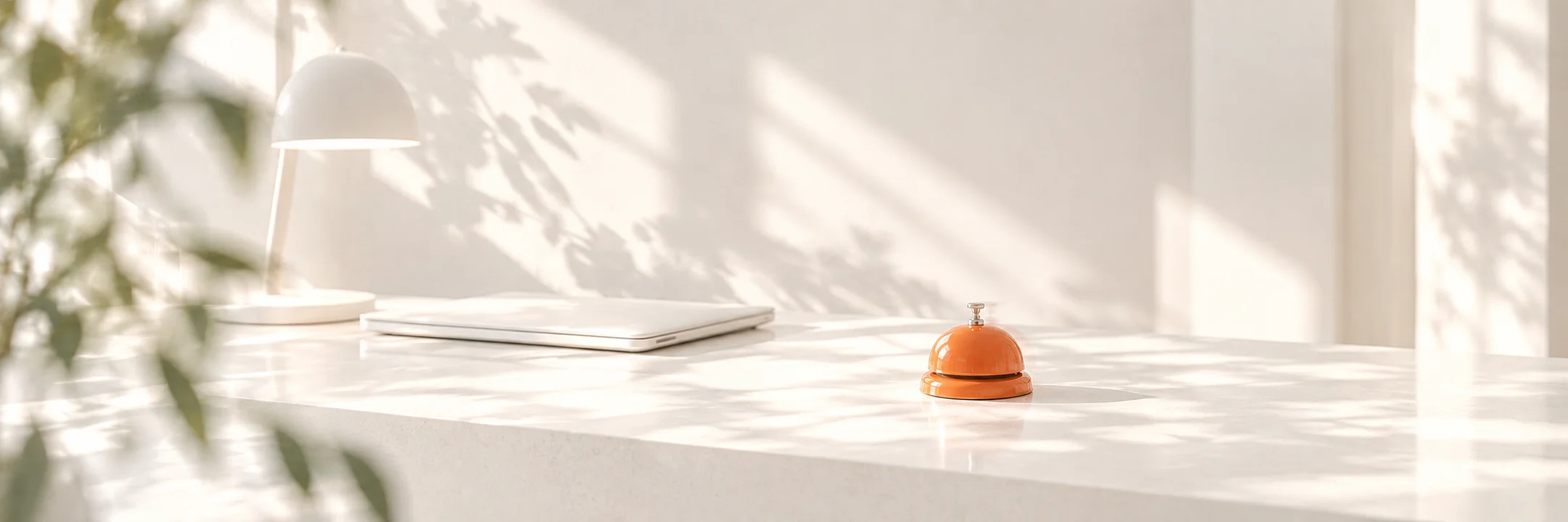 Une sonnette de comptoir orange sur un comptoir blanc