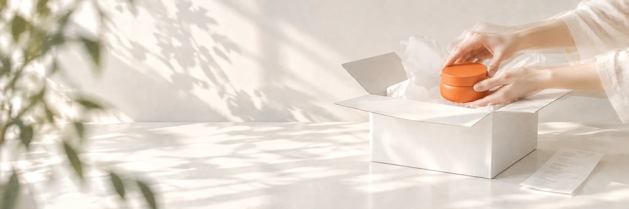 Un pot de crème orange glissé dans un carton de commande, à côté de son ticket