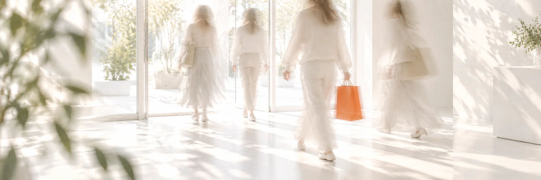 Des clients entrent dans une boutique lumineuse, l’un porte un sac orange